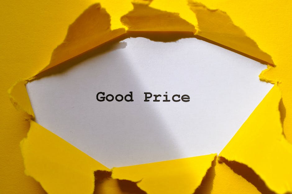 A piece of yellow paper is torn open from the top, revealing a white interior with the words 'Good Price' printed in black text. The torn edges of the paper are jagged and irregular, exposing the message inside. The image suggests a concept related to cost-effective or affordable house removals, with the torn paper symbolising uncovering value or transparency in pricing. This visual could be associated with professional furniture transport and packing services offered by Man with Van Woolwich, as part of their house removals or relocation process, emphasizing clarity and good value in moving quotes.